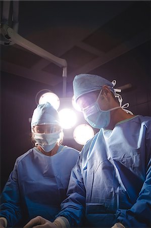 simsearch:6109-08829999,k - Surgeons performing operation in operation room at the hospital Foto de stock - Sin royalties Premium, Código: 6109-08720191