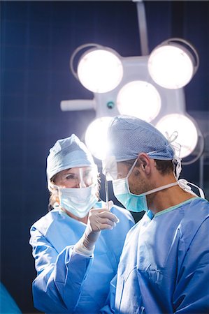 simsearch:400-06734621,k - Smiling surgeons interacting in operation room at hospital Stock Photo - Premium Royalty-Free, Code: 6109-08720194