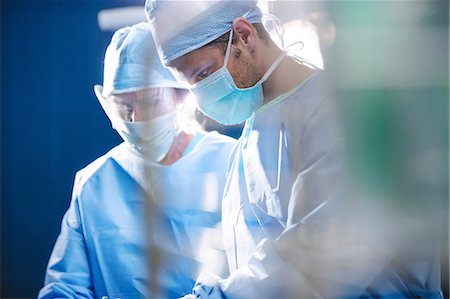 simsearch:400-06734621,k - Surgeons performing operation in operation room at the hospital Stock Photo - Premium Royalty-Free, Code: 6109-08720195