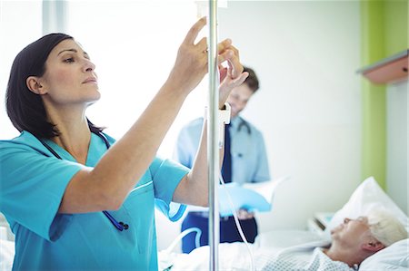 simsearch:400-04449853,k - Nurse checking a saline drip in hospital Photographie de stock - Premium Libres de Droits, Code: 6109-08720275