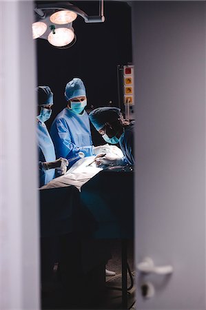 simsearch:6109-08830118,k - Surgeons performing operation in operation room at the hospital Foto de stock - Sin royalties Premium, Código: 6109-08720201