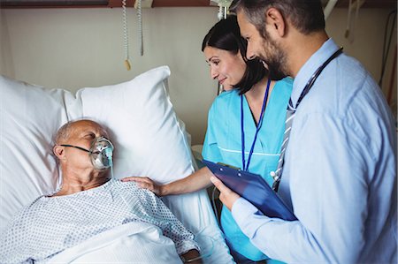 Nurse consoling senior patient with doctor in hospital Stock Photo - Premium Royalty-Free, Code: 6109-08720236