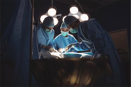 simsearch:6109-08829999,k - Surgeons performing operation in operation room at the hospital Foto de stock - Sin royalties Premium, Código: 6109-08720341