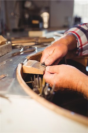 simsearch:6109-08720440,k - Attentive goldsmith shaping metal with pilers in workshop Stock Photo - Premium Royalty-Free, Code: 6109-08720386