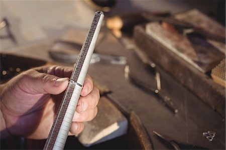 Close-up of goldsmith measuring ring in workshop Stock Photo - Premium Royalty-Free, Code: 6109-08720395