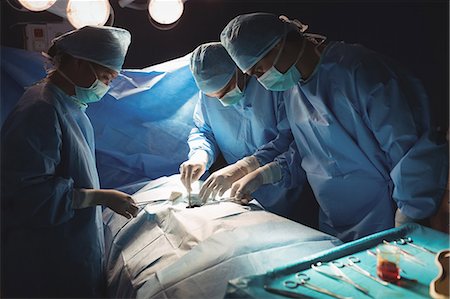 simsearch:6109-08830140,k - Surgeons performing operation in operation room at the hospital Foto de stock - Sin royalties Premium, Código: 6109-08720337