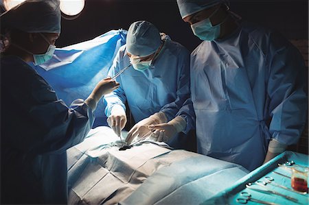 simsearch:6109-08830140,k - Surgeons performing operation in operation room at the hospital Foto de stock - Sin royalties Premium, Código: 6109-08720338