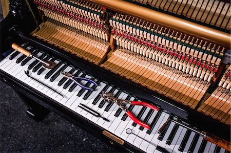 Close-up of repairing tools kept on old piano keyboard Foto de stock - Royalty Free Premium, Número: 6109-08720464