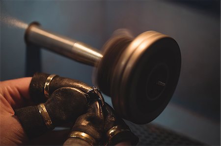 Close-up of goldsmith polishing ring in workshop Stock Photo - Premium Royalty-Free, Code: 6109-08720436