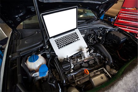 Cars with laptop on open hood for servicing at repair garage Stock Photo - Premium Royalty-Free, Code: 6109-08722486