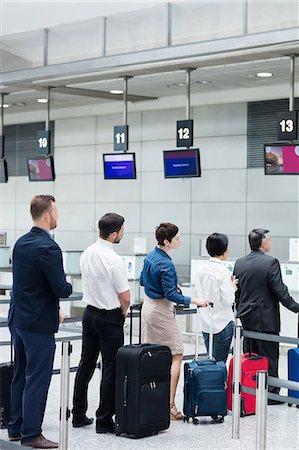 Passengers waiting in queue at a check-in counter with luggage inside the airport terminal Photographie de stock - Premium Libres de Droits, Code: 6109-08722488