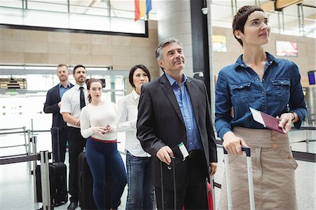 simsearch:6109-08722669,k - Passengers waiting in queue at a check-in counter with luggage inside the airport terminal Photographie de stock - Premium Libres de Droits, Code: 6109-08722494