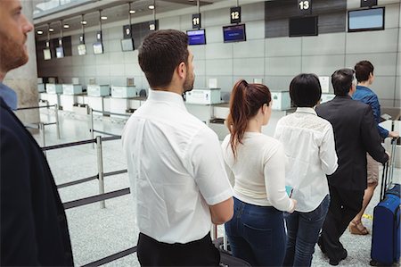 simsearch:400-08653702,k - Passengers waiting in queue at a check-in counter with luggage inside the airport terminal Stock Photo - Premium Royalty-Free, Code: 6109-08722495
