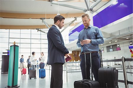 simsearch:6109-08802775,k - Business people waiting at check-in counter with luggage in airport terminal Photographie de stock - Premium Libres de Droits, Code: 6109-08722540