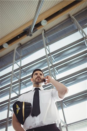 simsearch:6109-08722569,k - Pilot talking on mobile phone in waiting area at airport terminal Stockbilder - Premium RF Lizenzfrei, Bildnummer: 6109-08722571