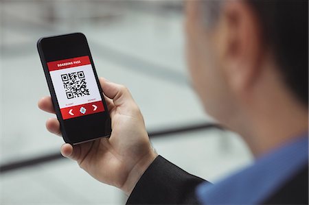 Business man using mobile phone in airport terminal Stock Photo - Premium Royalty-Free, Code: 6109-08722584