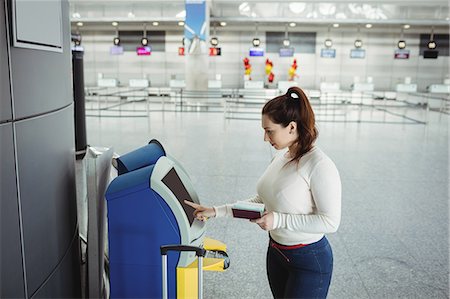 simsearch:6109-08722675,k - Traveller using self service check-in machine at airport Fotografie stock - Premium Royalty-Free, Codice: 6109-08722506