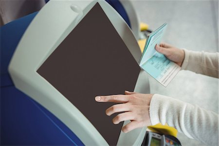 Traveller using self service check-in machine at airport Fotografie stock - Premium Royalty-Free, Codice: 6109-08722508