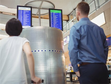 simsearch:400-08653702,k - Travellers looking at departure and arrival screen board display in airport Fotografie stock - Premium Royalty-Free, Codice: 6109-08722530