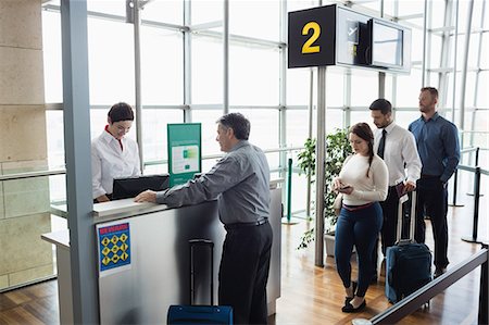 simsearch:6109-08722754,k - Passengers waiting in queue at check-in counter in airport terminal Photographie de stock - Premium Libres de Droits, Code: 6109-08722655