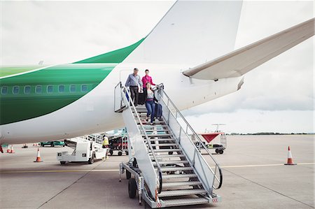 Passengers exit airplane down stairs at airport Stock Photo - Premium Royalty-Free, Code: 6109-08722693