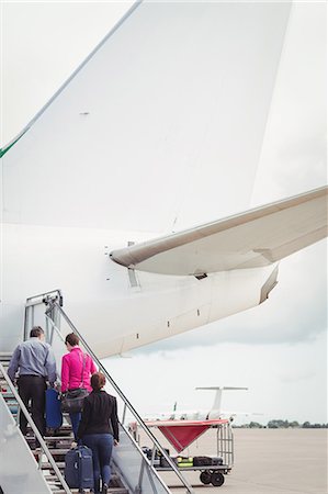 Passengers climbing on the stairs and entering into the airplane at airport Foto de stock - Sin royalties Premium, Código: 6109-08722692