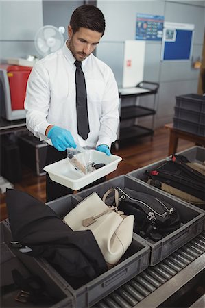 simsearch:6109-08722602,k - Security officer holding tray of liquid and key in airport Photographie de stock - Premium Libres de Droits, Code: 6109-08722606