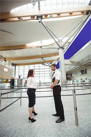 pilote (avion) - Pilot and flight attendant interacting with each other in airport terminal Photographie de stock - Premium Libres de Droits, Code: 6109-08722745