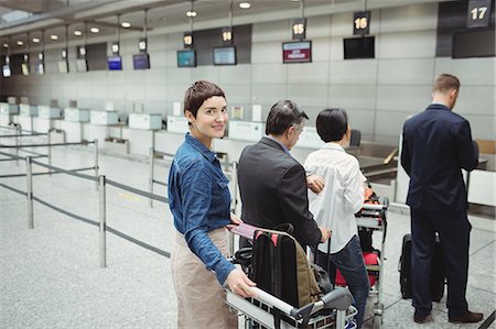 simsearch:6116-07086481,k - Passengers waiting in queue at a check-in counter with luggage inside the airport terminal Stock Photo - Premium Royalty-Free, Code: 6109-08722757