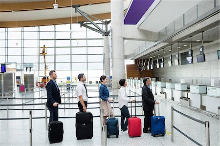 simsearch:6116-07086481,k - Passengers waiting in queue at a check-in counter with luggage inside the airport terminal Stock Photo - Premium Royalty-Free, Code: 6109-08722764