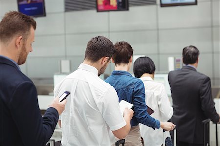 simsearch:6109-08722669,k - Passengers waiting in queue at a check-in counter with luggage inside the airport terminal Photographie de stock - Premium Libres de Droits, Code: 6109-08722768