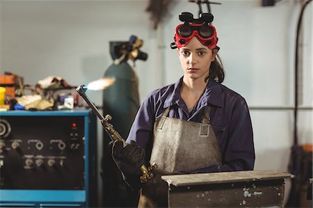 simsearch:6109-08722895,k - Female welder holding welding torch in workshop Stock Photo - Premium Royalty-Free, Code: 6109-08722787