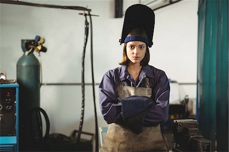 simsearch:6109-08722895,k - Portrait of female welder standing with arms crossed in workshop Foto de stock - Sin royalties Premium, Código: 6109-08722786