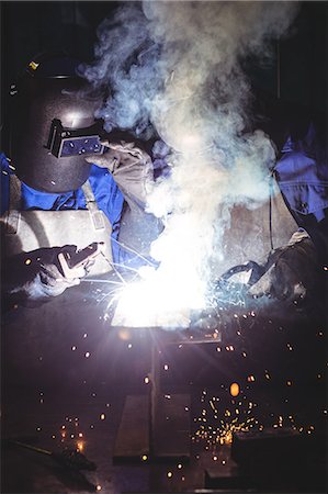 Two welders working on a piece of metal in workshop Foto de stock - Sin royalties Premium, Código: 6109-08722789