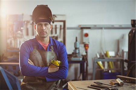 simsearch:6109-08722814,k - Portrait of male welder standing with arms crossed in workshop Foto de stock - Royalty Free Premium, Número: 6109-08722797