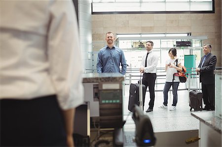 Passengers waiting in queue at check-in counter in airport terminal Stock Photo - Premium Royalty-Free, Code: 6109-08722721