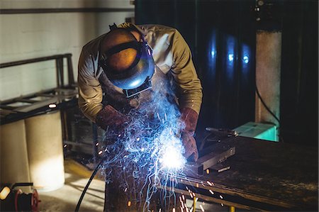 simsearch:6113-08424286,k - Male welder working on a piece of metal in workshop Stock Photo - Premium Royalty-Free, Code: 6109-08722843