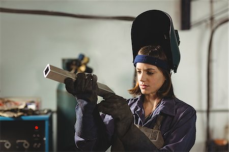 simsearch:6109-08722895,k - Female welder examining a piece of metal in workshop Stock Photo - Premium Royalty-Free, Code: 6109-08722847