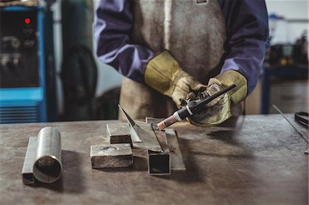 simsearch:6109-08722861,k - Mid-section of female welder working on a piece of metal in workshop Stockbilder - Premium RF Lizenzfrei, Bildnummer: 6109-08722857