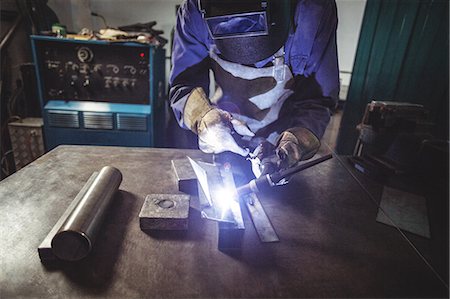 simsearch:6109-08722895,k - Female welder working on a piece of metal in workshop Stock Photo - Premium Royalty-Free, Code: 6109-08722859