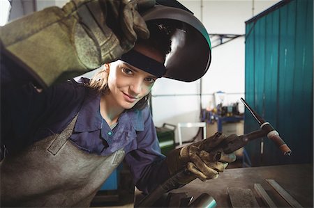 simsearch:6109-08722895,k - Female welder holding welding torch in workshop Stock Photo - Premium Royalty-Free, Code: 6109-08722864
