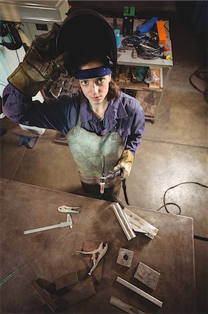 simsearch:6109-08722895,k - Female welder holding welding torch in workshop Stock Photo - Premium Royalty-Free, Code: 6109-08722866