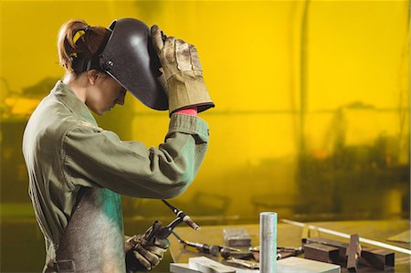 simsearch:6109-08722895,k - Female welder holding welding torch in workshop Stock Photo - Premium Royalty-Free, Code: 6109-08722868