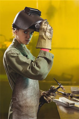 simsearch:6109-08722895,k - Female welder holding welding torch in workshop Stock Photo - Premium Royalty-Free, Code: 6109-08722869