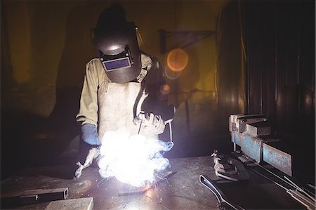 Female welder working on a piece of metal in workshop Stock Photo - Premium Royalty-Free, Code: 6109-08722877