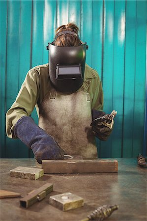 simsearch:6109-08722895,k - Female welder holding welding arch in workshop Foto de stock - Sin royalties Premium, Código: 6109-08722879