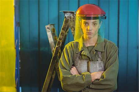 simsearch:6109-08722895,k - Portrait of female welder standing with arms crossed in workshop Foto de stock - Sin royalties Premium, Código: 6109-08722886