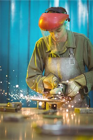 simsearch:6109-08722895,k - Female welder using circular saw in workshop Stock Photo - Premium Royalty-Free, Code: 6109-08722888