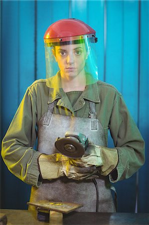 Portrait of female welder holding circular saw in workshop Photographie de stock - Premium Libres de Droits, Code: 6109-08722890
