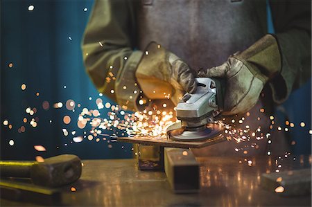 simsearch:6109-08722895,k - Mid-section of female welder using circular saw in workshop Stock Photo - Premium Royalty-Free, Code: 6109-08722892